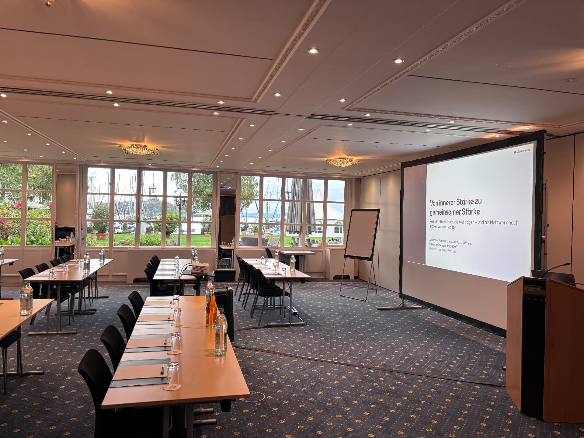 Tagungsraum im Yachthotel Prien am Chiemsee mit Beamer-Leinwand und Titelfolie „Von innerer Stärke zu gemeinsamer Stärke“