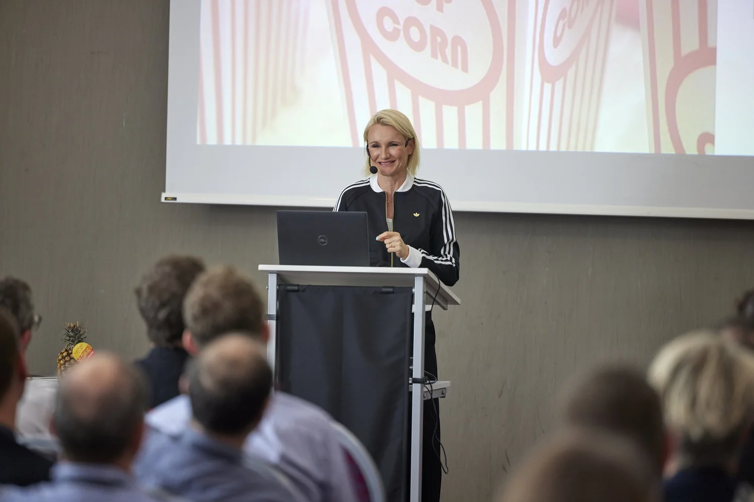 Henriette Hochstein-Frädrich Keynote am Rednerpult mit Popcorn-Visual – Vortrag mit Humor zu Wandel, Aufmerksamkeit und Zukunft