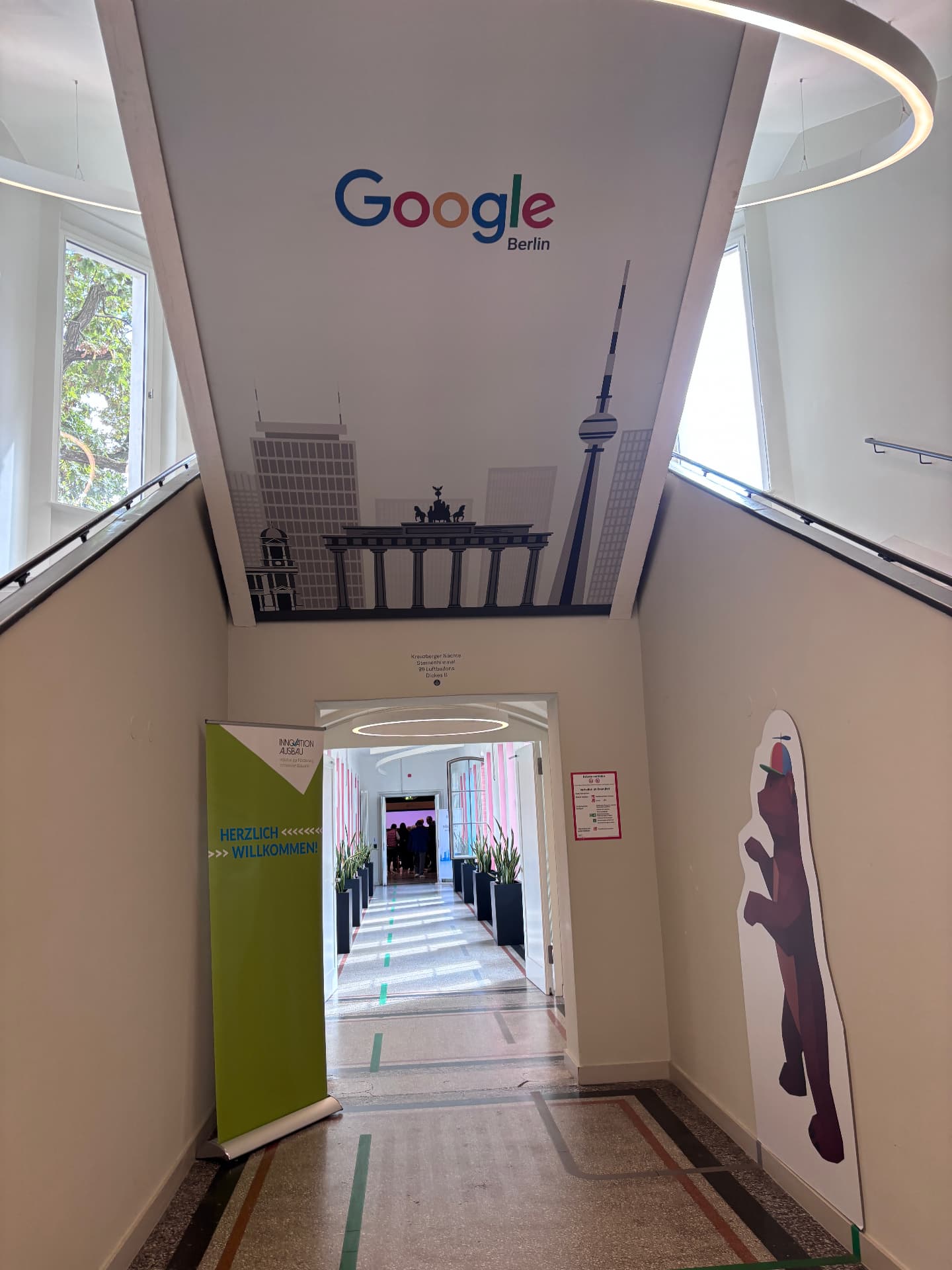 Eingangsbereich des Google Office Berlin im Forum an der Museumsinsel mit Willkommens-Banner von Innovation Ausbau e.V. zum Zukunftstag Ausbau und Gebäudetechnik