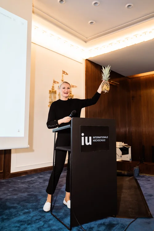 Henriette Hochstein-Frädrich mit Ananas an der IU Internationale Hochschule – Keynote-Speakerin mit Markenzeichen und Humor