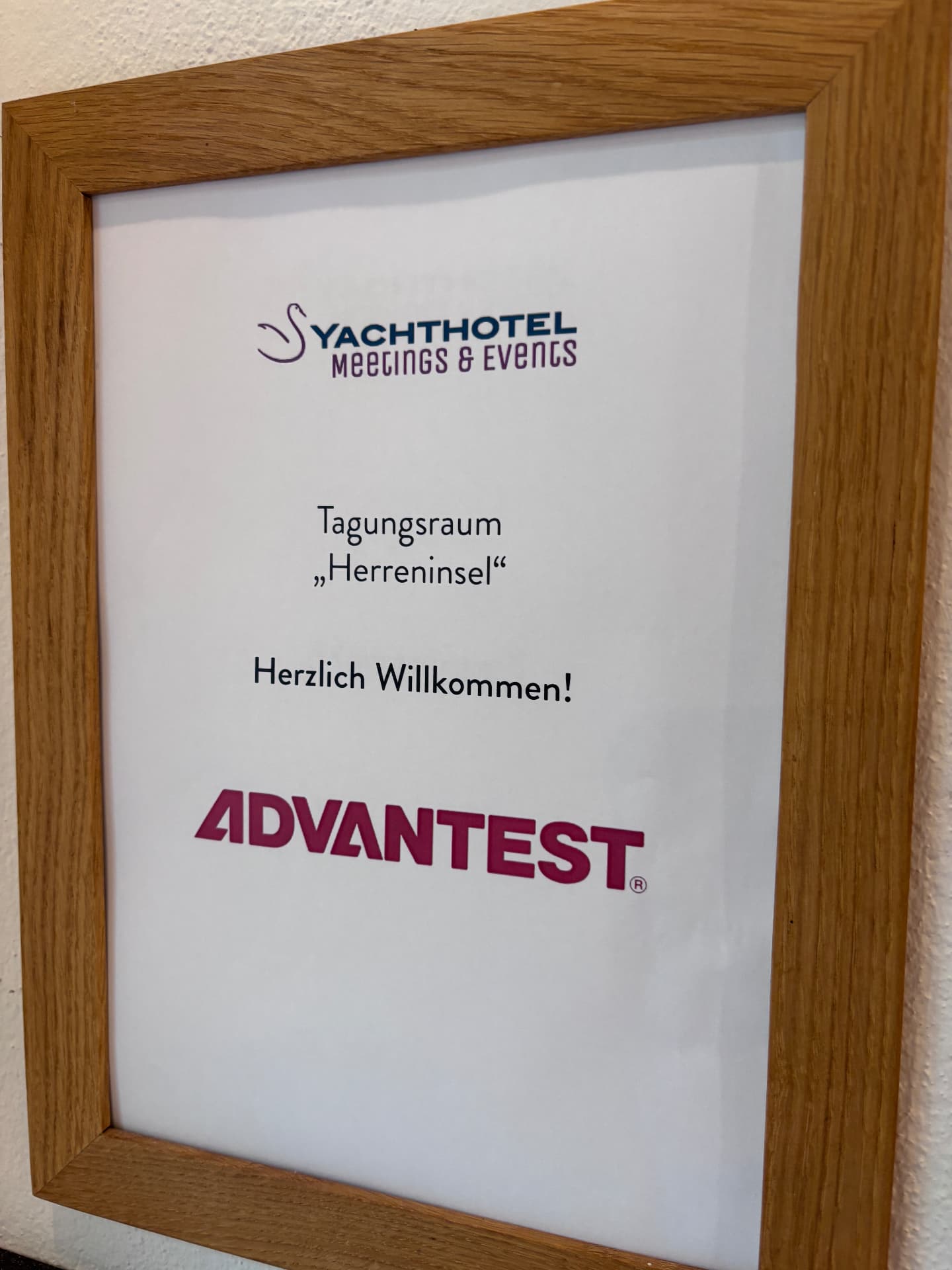 Türschild des Tagungsraums „Herreninsel“ mit Advantest-Logo und Willkommensgruß
