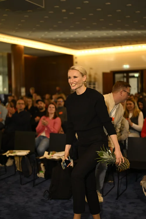 Henriette Hochstein-Frädrich Keynote-Speakerin auf der Bühne mit Ananas – Vortrag zu Veränderung, Resilienz und Wandel